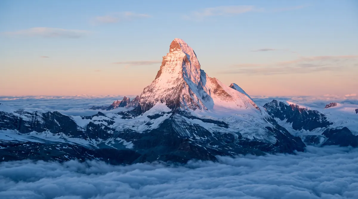 Alpenglow on a snowy peak above a sea of clouds